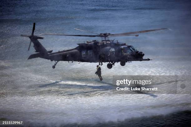 Navy SEAL jumps into Tampa Bay from an MH-60 Blackhawk helicopter, piloted by the U.S. Army's 160th Special Operations Aviation Regiment during a...