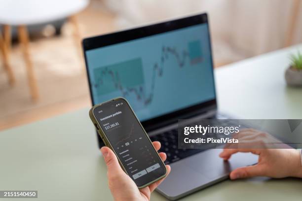 analyse der finanzmärkte auf laptop und smartphone - fondsmanager stock-fotos und bilder