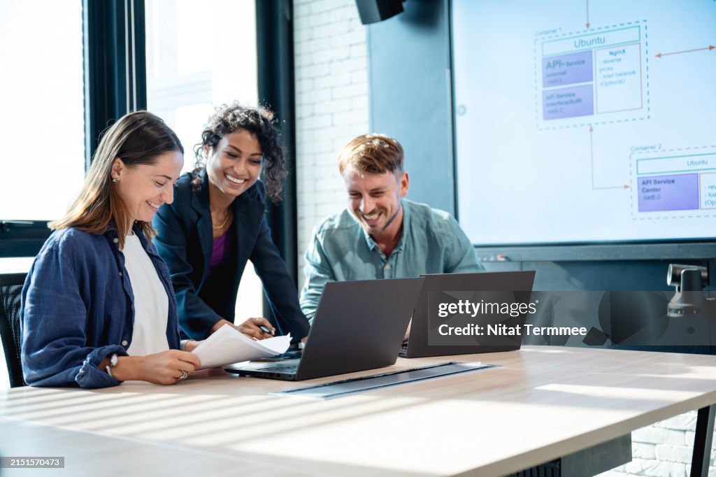 Collaboration drives developer productivity is vital in software development. A team of software developer having discussion in UX and UI design based on a customer requirement during a meeting in a startup tech office.