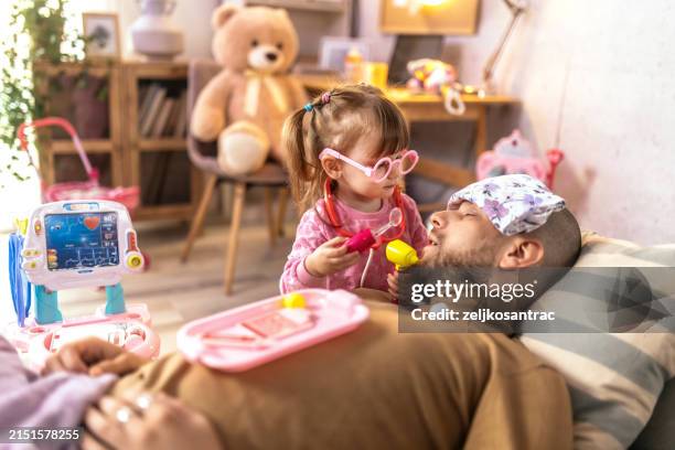 niña jugando al médico con el padre en casa - disfrazarse fotografías e imágenes de stock