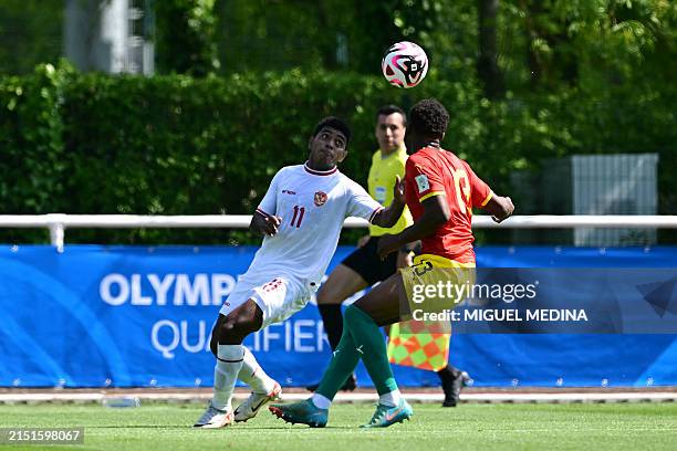Indonesia's midfielder#11 Jeam Kelly Sroyer fights for the ball with Guinea's defender Madiou Keita during the pre-Olympic play-off match between...