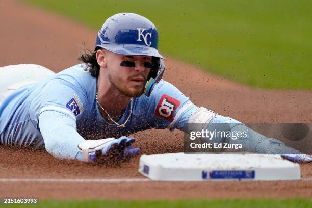 Bobby Witt Jr. #7 of the Kansas City Royals slides into third for a triple in the first inning against the Texas Rangers at Kauffman Stadium on May...