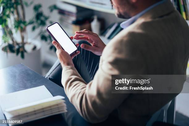 professioneller mann mit smartphone am schreibtisch - über die schulter blicken stock-fotos und bilder