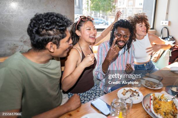 a group of people are sitting around a table eating and laughing - vintage restaurant interior stock pictures, royalty-free photos & images