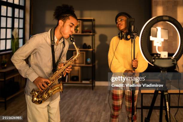 musicians using a cellphone for a vlog - saxophone stock pictures, royalty-free photos & images