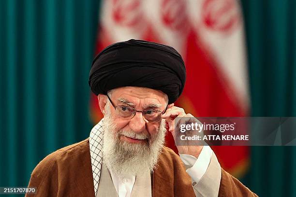 Iran's Supreme Leader Ayatollah Ali Khamenei adjusts his eyeglasses during a press conference after casting his ballot for the parliamentary runoff...