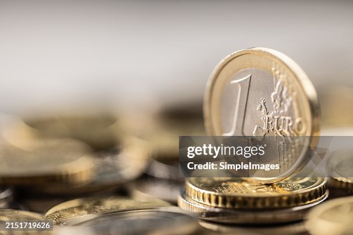 One euro coin vertical placed on a pile of euro coins. Euro money concept. One euro coin vertical placed on a pile of euro coins. Euro money concept.
