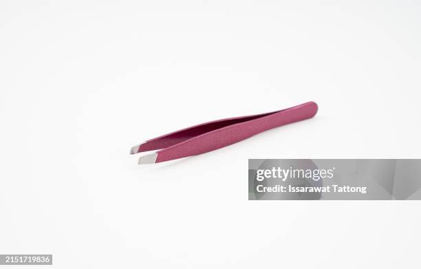 bright pink cosmetic eyebrow tweezers isolated on white background - pinça utensílio de servir - fotografias e filmes do acervo