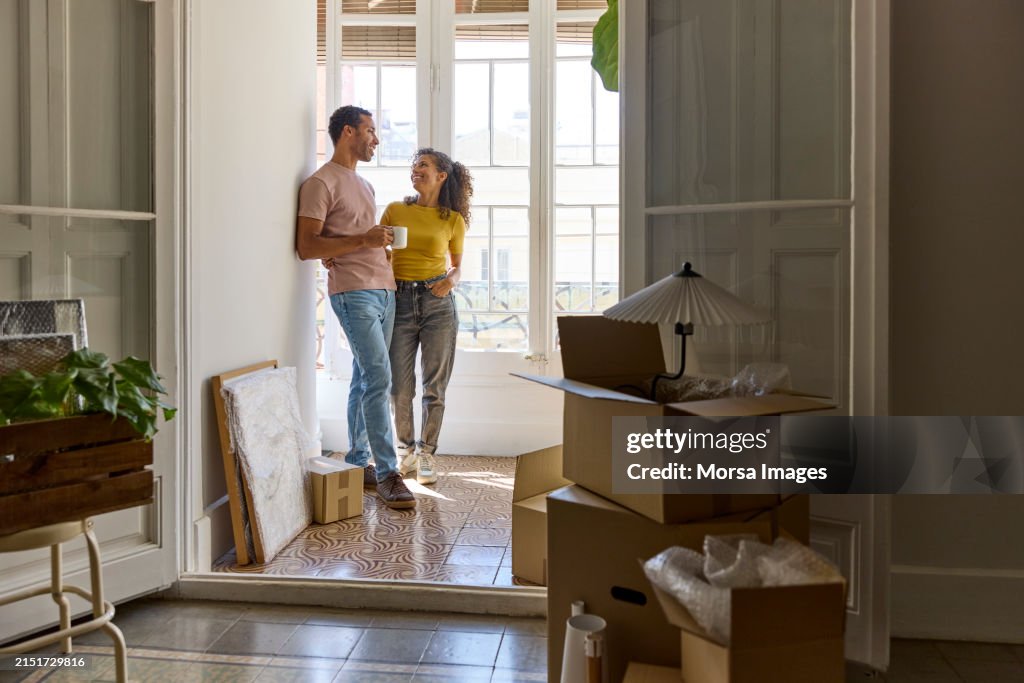 Smiling man and woman talking in balcony at home