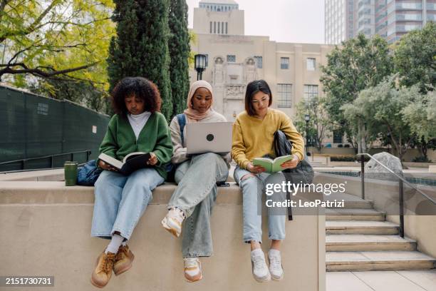 three teenage student friends studying outdoors in the university campus - university of california los angeles stockfoto's en -beelden