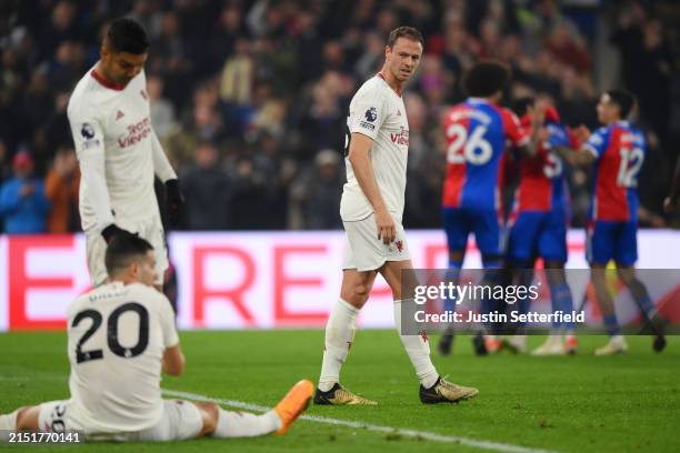 Jonny Evans of Manchester United looks dejected as he looks back towards Casemiro and Diogo Dalot after Tyrick Mitchell of Crystal Palace scored his...