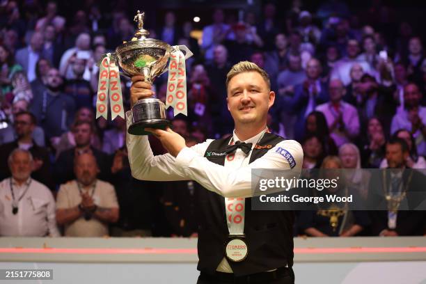 Kyren Wilson of England poses with the Cazoo World Snooker Championship trophy after victory in the Final match between Jak Jones of Wales and Kyren...