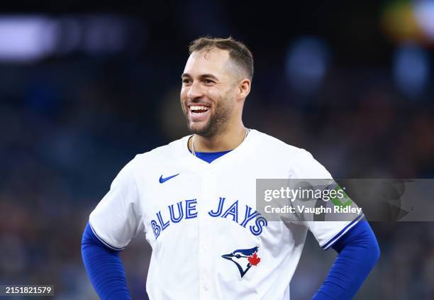 George Springer of the Toronto Blue Jays jokes with players in the Kansas City Royals dugout during a game at Rogers Centre on May 01, 2024 in...