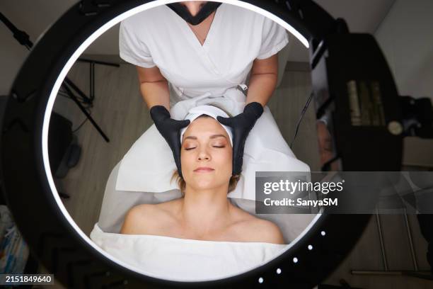 happy woman receiving a beauty treatment - especialista en belleza fotografías e imágenes de stock