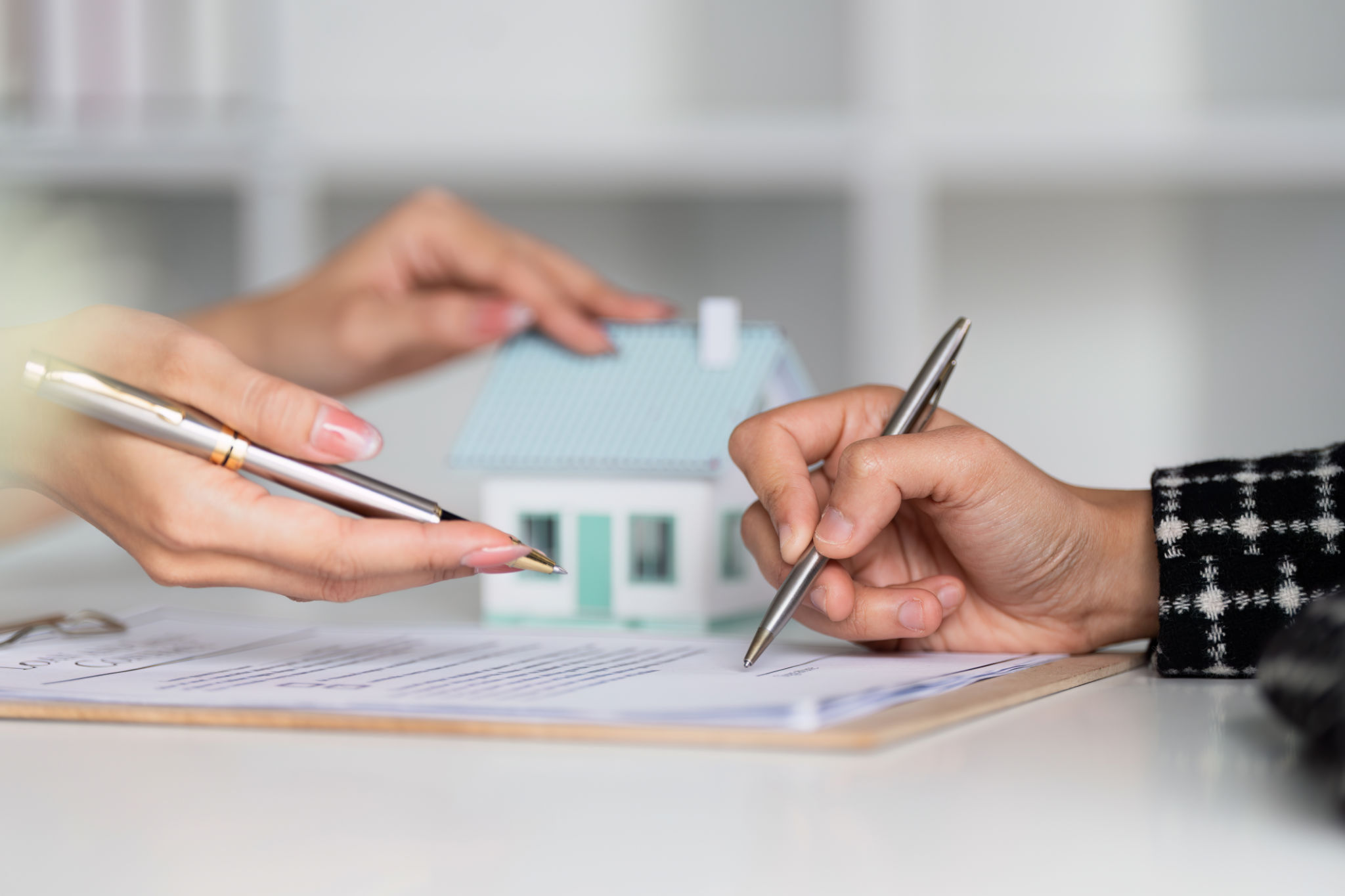 Real estate agent offer hand for customer sign agreement contract signature for buy or sell house. Real estate concept contact agreement concept Real estate agent offer hand for customer sign agreement contract signature for buy or sell house. Real estate concept contact agreement concept