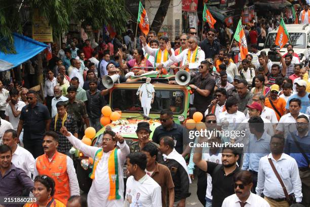 Supporters of the ruling Bharatiya Janata Party are holding party flags and a cutout of PM Modi during a campaign rally in Kolkata, India, on May 10...
