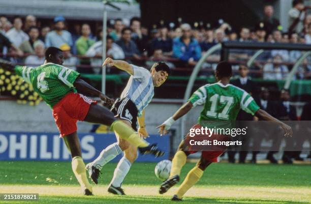 Cameroonian footballers Benjamin Massing and Victor N'Dip challenge Argentine footballer Diego Maradona during the 1990 FIFA World Cup Group B match,...