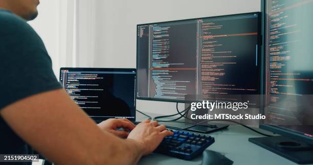 closeup young man software developers using computer to write code application program for ai technology development at desk with multiple screens work at home office. programmer development. - html css foto e immagini stock