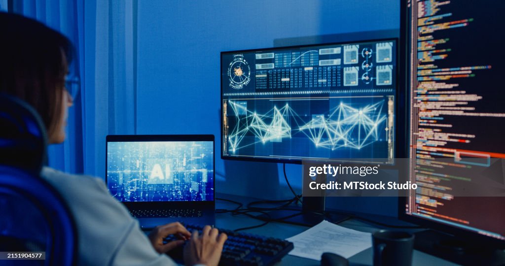 Young Asian woman software developers using computer to write code application program for AI technology at desk with multiple screens work at home office night. Programmer development.