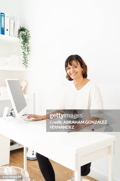 physiotherapist sitting on desk using computer - pelvic floor stock pictures, royalty-free photos & images