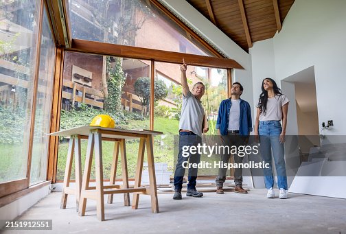 Bauunternehmer im Gespräch mit Kunden, die ihr Haus renovieren Bauunternehmer im Gespräch mit Kunden, die ihr Haus renovieren