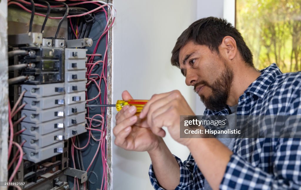 Elektriker, der einen Sicherungskasten an einem Haus repariert