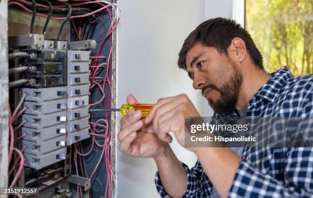 electrician fixing a fuse box at a house - eletricidade imagens e fotografias de stock