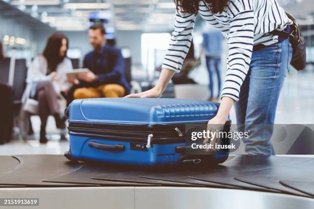 buscar a mala da linha de reclamação de bagagem de viagem - área de retirada de bagagem - fotografias e filmes do acervo
