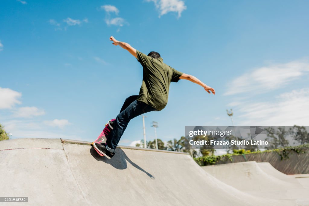 Young man skateboarding at the skate park outdoors
