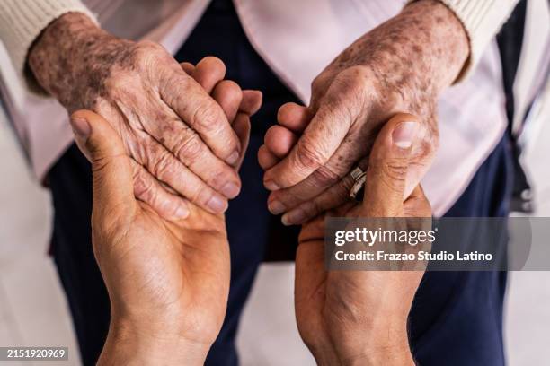 nahaufnahme einer pflegekraft, die händchen hält, ältere patientin - fürsorglichkeit stock-fotos und bilder
