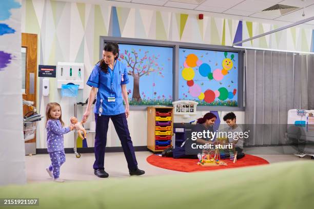little girl with nurse on hospital ward - paediatrician stock pictures, royalty-free photos & images