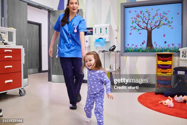 little girl with nurse on hospital ward - paediatrician stock pictures, royalty-free photos & images