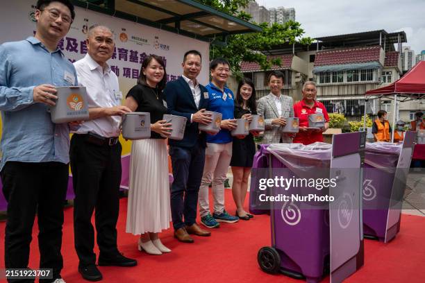 People are holding boxes that will be used for carrying food waste while standing next to food waste bins in Hong Kong, on January 9, 2023.