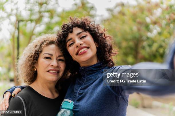 madre e hija tomándose una selfie en el parque público - punto de vista de la cámara - punto de vista de una cámara fotografías e imágenes de stock