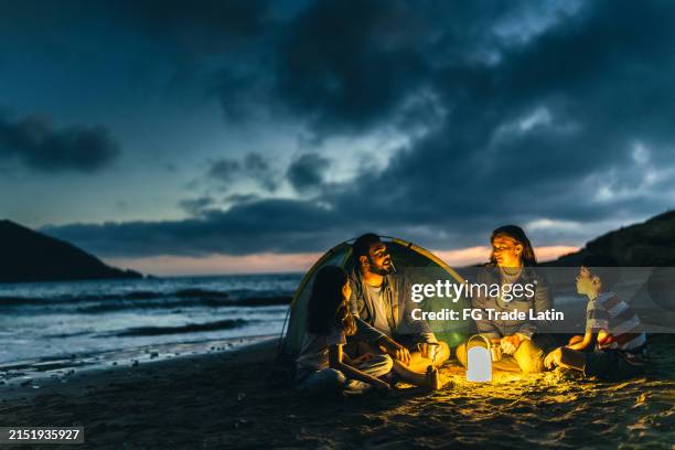 family talking and camping on the beach - camping night stock pictures, royalty-free photos & images