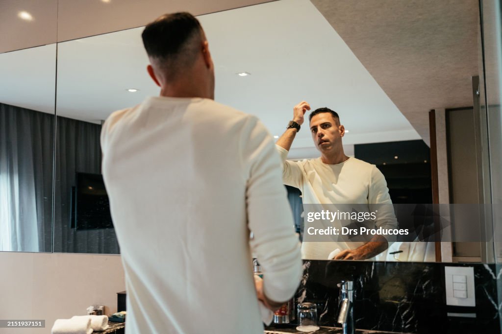Businessman in front of mirror in hotel room