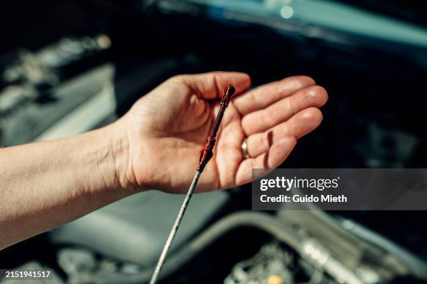 woman checking the oil in a car engine at home. - dipstick stock pictures, royalty-free photos & images
