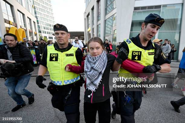 Swedish climate activist Greta Thunberg wearing the keffiyeh scarf is removed by police during a pro-Palestinian demonstration outside the Malmo...