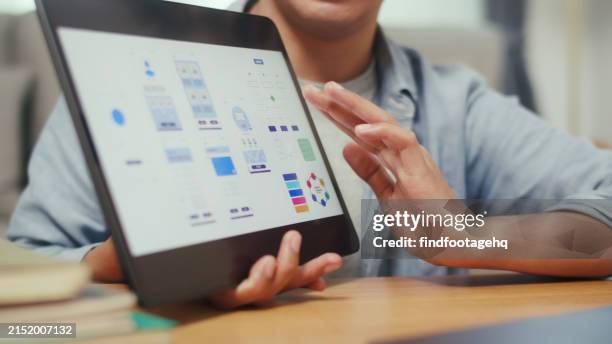graphic designer exploring ui/ux on digital tablet. - ux ui design stock pictures, royalty-free photos & images