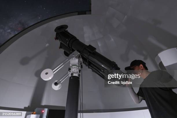 astronomer in photo telescope dome checking settings - astronomer stock pictures, royalty-free photos & images