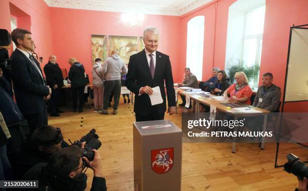 Lithuania's President Gitanas Nauseda poses for photographers as he is about to cast his ballot during the first round of Lithuania's presidential...