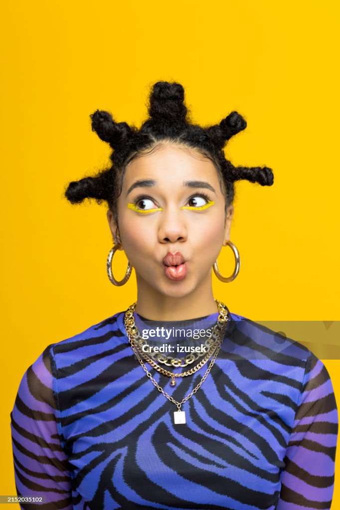 Gen Z teen girl posing against yellow background