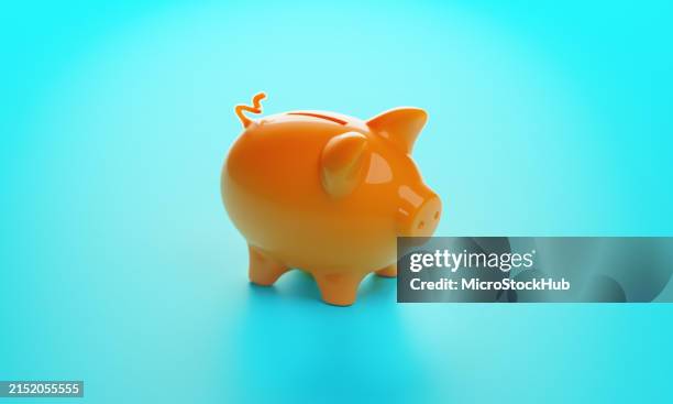 orange piggy bank on blue - spaarvarken stockfoto's en -beelden