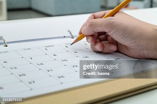 カレンダーページに鉛筆で書く女性の手 カレンダーページに鉛筆で書く女性の手