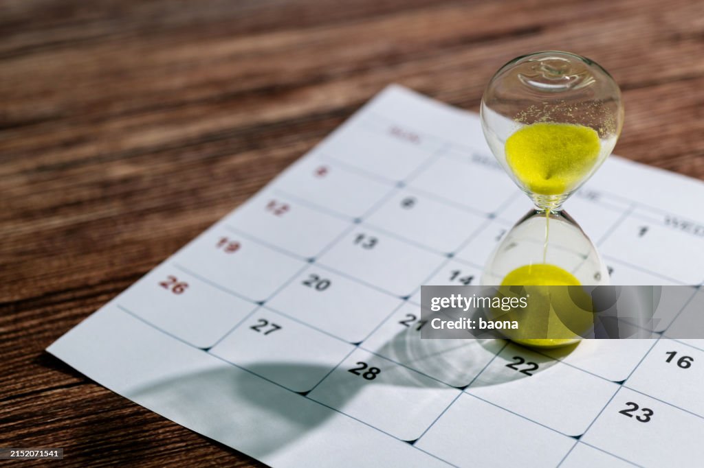 Kalender und Sanduhr auf dem Tisch