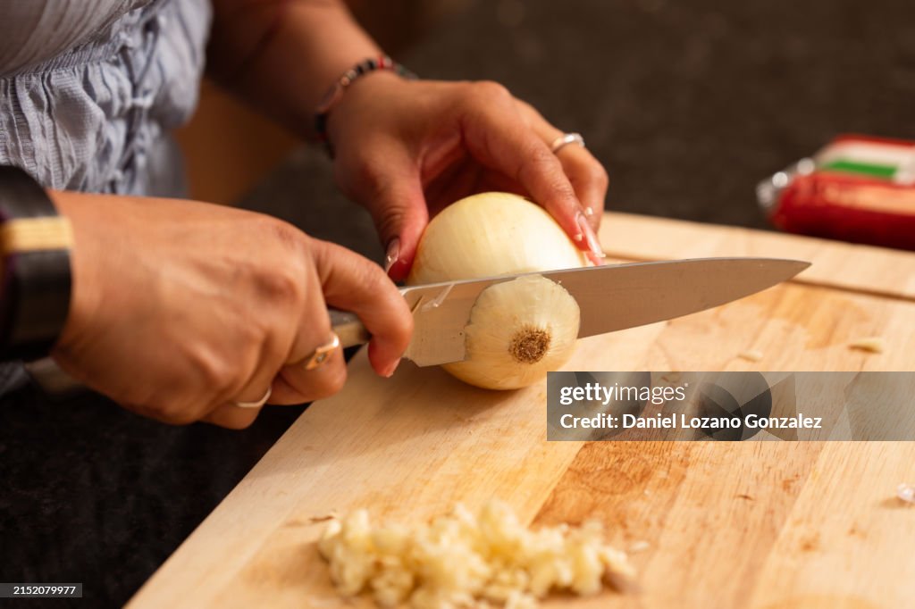 Woman cutting onion on chopping board