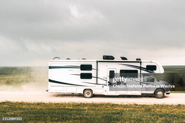 motorhome traveling on a dusty road - camper van stock pictures, royalty-free photos & images