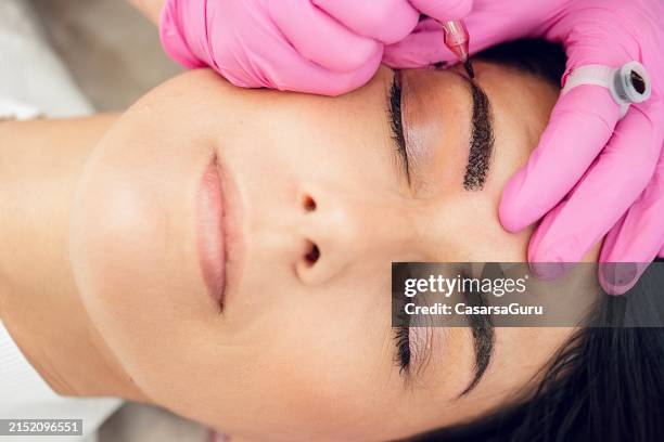 traitement des sourcils en poudre dans un salon de spa - directement au-dessus - maquillage permanent photos et images de collection