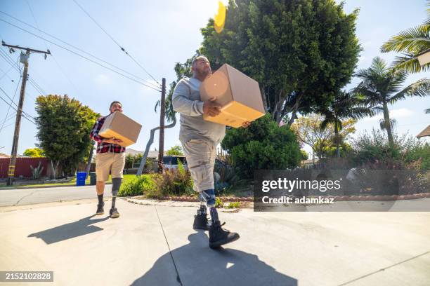 disabled hispanic veteran amputees moving boxes - movers carrying boxes stock pictures, royalty-free photos & images