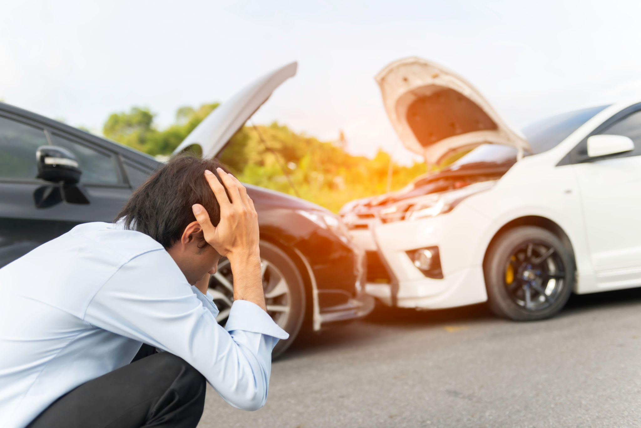 young woman with smartphone by the damaged car after a car accident, making a phone call and for insurance agent to quick attention young woman with smartphone by the damaged car after a car accident, making a phone call and for insurance agent to quick attention